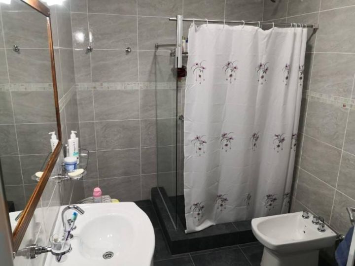 Casa amplia de dos dormitorios, tres baños, amplia cochera y patio
